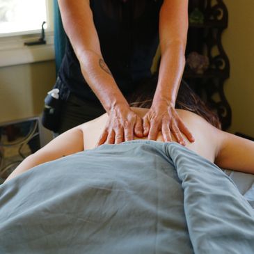 Massage therapist with hands on clients back in session