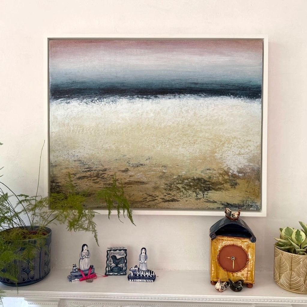 a painting with texture and the sea sits above a mantle piece in a collectors home