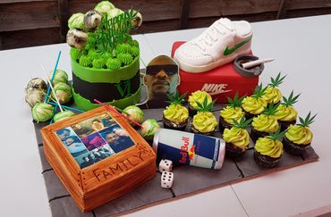 Custom birthday cake with green and white theme, sneakers, cupcakes, and family photos.