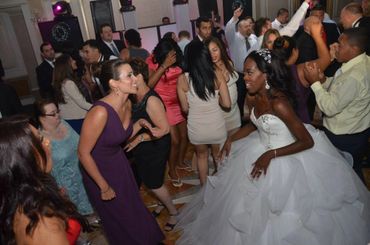 Bride and guests dancing joyfully at a wedding reception.
