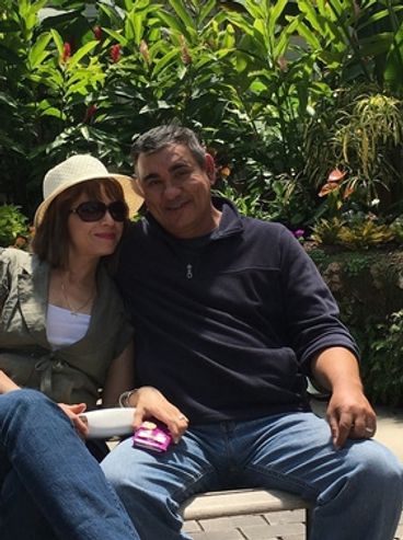 A couple relaxing together on a bench.