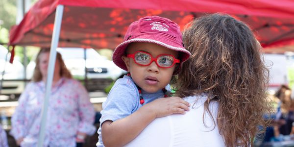 A boy with red glasses looks at the camera.