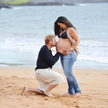 Husband kissing pregnant wife belly.