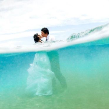 wedding couple kissing in the ocean