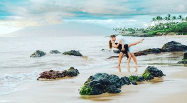 Couple practicing dancing poses at Maui beach.