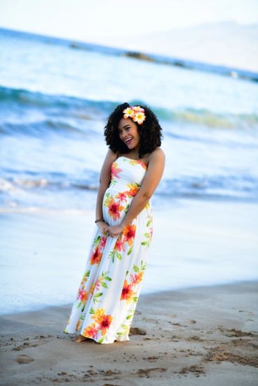 Pregnant woman smiling at the Maui beach.