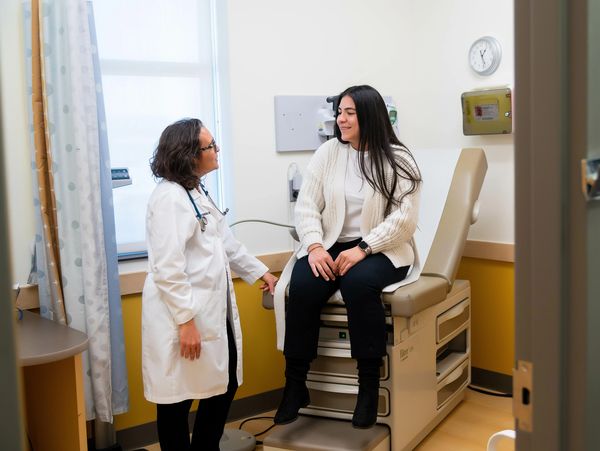 Doctor and patient discussing health in clinic room.