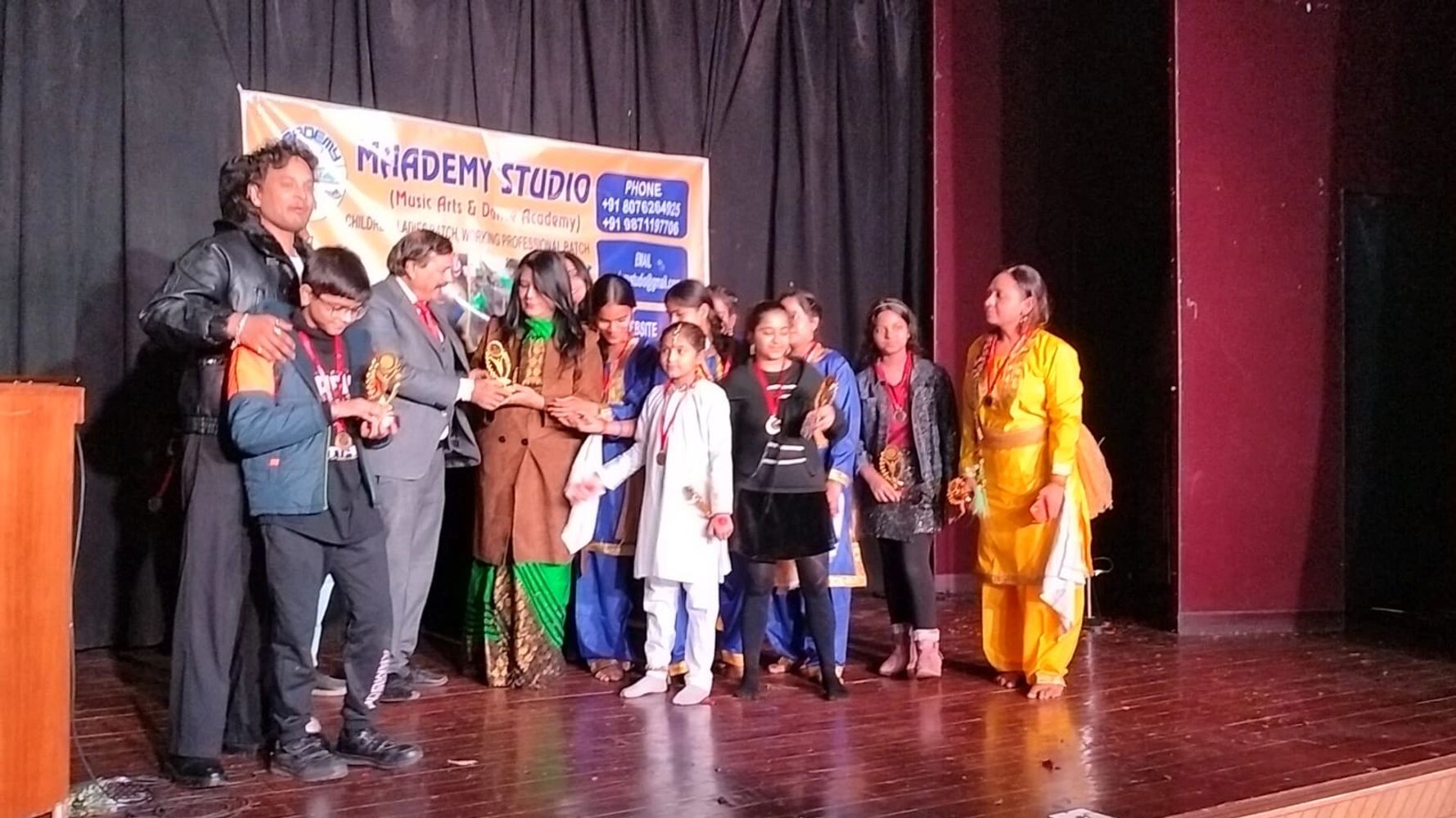 Group of people receiving awards on stage at MiAdemy Studio event.