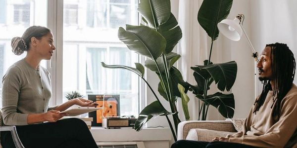 Two people having a serious conversation in a cozy room.