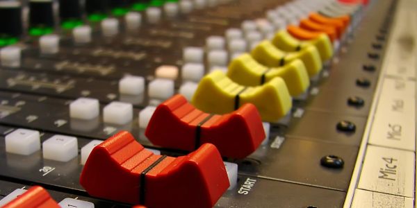 Close-up of colorful audio mixer faders.
