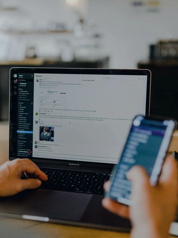 Professional using laptop and mobile for RIA client communication