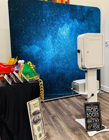 A photo booth setup with fun props and a starry night backdrop.