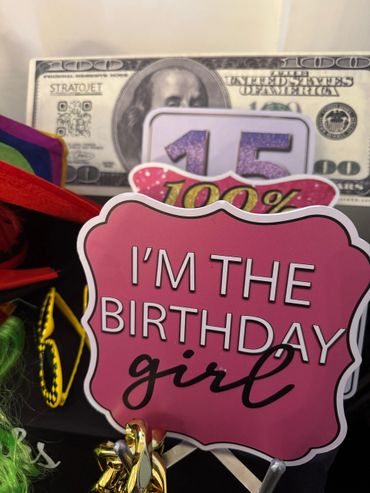 Birthday display with a sign saying "I'm the birthday girl" and a fake $100 bill.