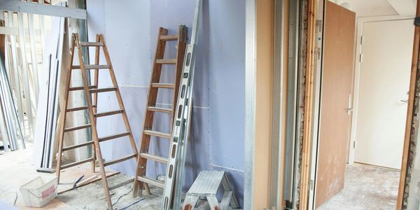 Construction site with ladders and building materials.