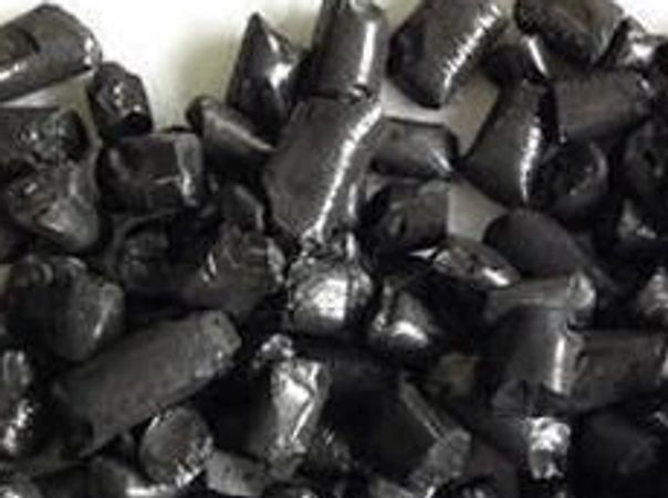 Close-up of shiny black charcoal briquettes.