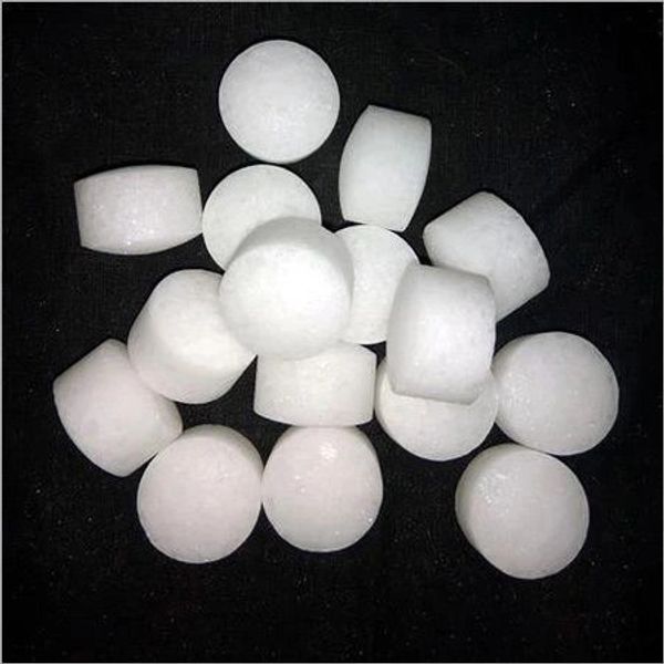 White cylindrical tablets scattered on a black surface.