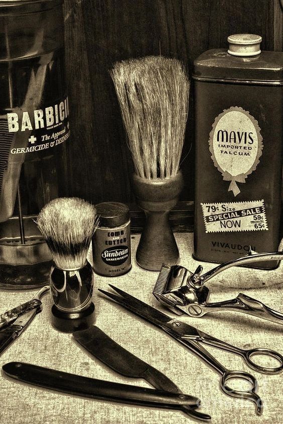 Vintage barber tools and grooming products displayed on a surface.