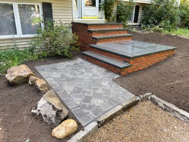 Newly built brick steps with granite tops and paver pathway.