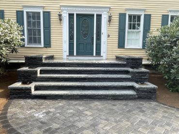 Elegant entrance with stone steps and a teal door.