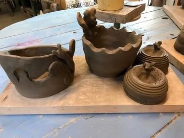 Handmade clay pottery pieces on a wooden board.