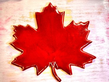 Red maple leaf-shaped object on a textured surface.