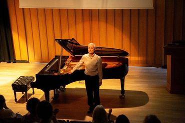 Marcus Andrews bowing in front of the piano at Fishmonger’s Hall, Britten Sch., Greshams, MSSF 2025.