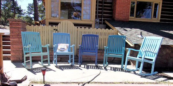 Five blue rocking chairs on sunny patio waiting for you!