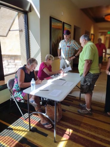 Pam Browning and Carol Enright check members in at the August meeting of RRAZRC