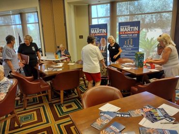 Members at the July meeting of RRAZRC purchase 50/50 raffle tickets