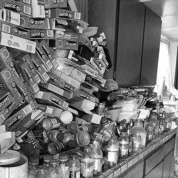 Trash piled up on the kitchen counter from a hoarder cleanup.