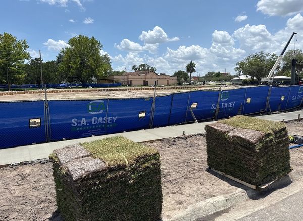 Stacks of sod ready for installation at a construction site.