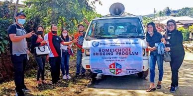 Group poses with van promoting homeschool bridging program.