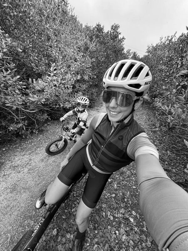 Cyclist woman and child on a forest trail.