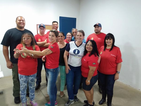 Group of people posing indoors, many wearing red shirts.
