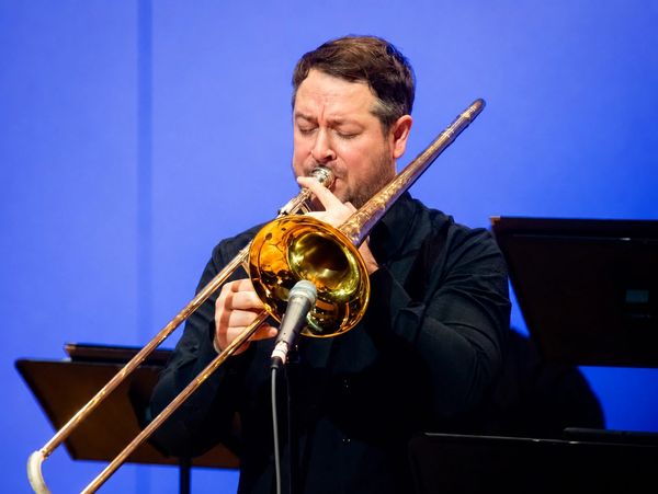 Man playing trombone on stage.