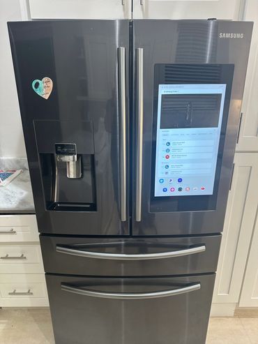 Modern Samsung refrigerator with touchscreen and water dispenser.
