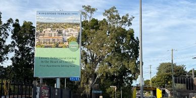 Billboard advertising Kingsford Terrace apartments in a suburban area.