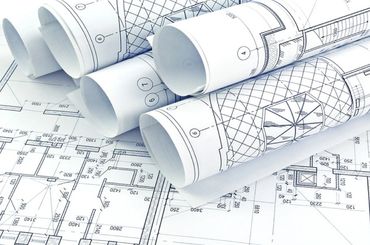 Rolled and flat architectural blueprints with detailed floor plans and measurements.