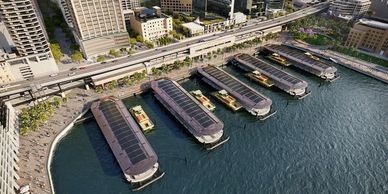 Aerial view of ferry wharves along a waterfront in a city.