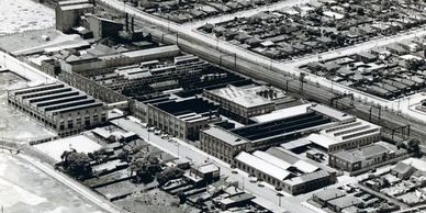 Aerial view of an industrial factory complex surrounded by residential neighborhoods.