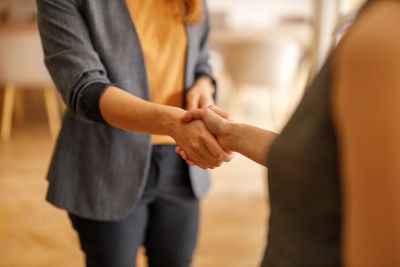 Two people shaking hands in a professional setting.
