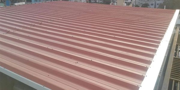 A red metal sheet roof installed on a building.