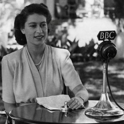 A woman seated at a table speaking into a BBC microphone.