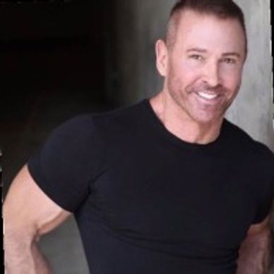 Smiling man in a black t-shirt posing confidently.