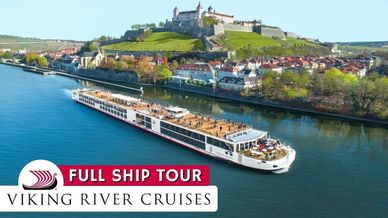 Viking River Cruises ship sailing on a scenic river with a historic castle in the background.