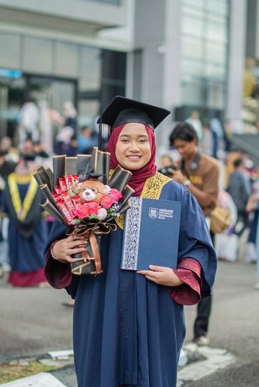 Graduate holding bouquet and diploma