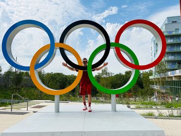 Didie Hamel-Jolette, athletic therapist,  behind the olympic rings at the olympic village in Paris