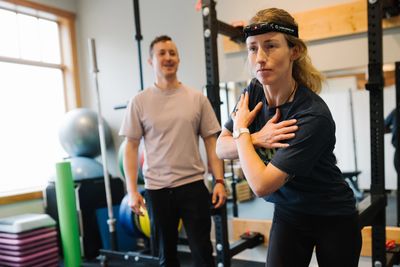 patient doing a vestibular drill with her athletic therapist, to improve performance in golfing