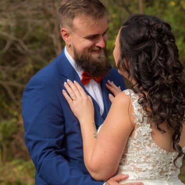 A joyful bride and groom share a loving moment outdoors.