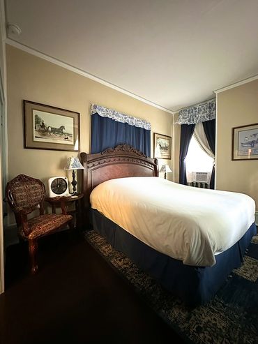 Cozy bedroom with vintage wooden furniture and blue curtains.